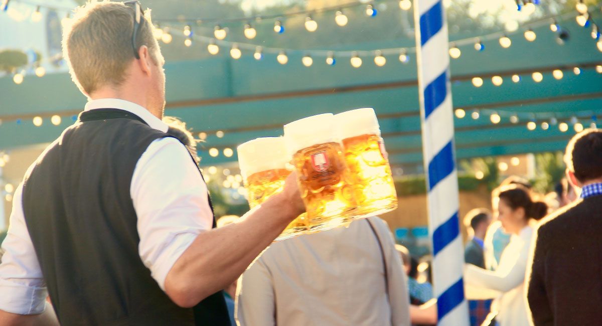 Person Carrying Large Mugs of Beer